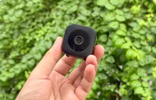 GuardHouse camera held in one hand outdoors